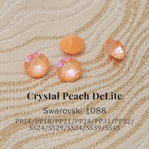 Puede incluir: Primer plano de varios cristales Swarovski Crystal Peach DeLite. Los cristales, de diversas formas, incluyendo redondas y ovaladas, tienen un color melocotón iridiscente. El texto en la imagen dice "Crystal Peach DeLite" y "Swarovski 1088".