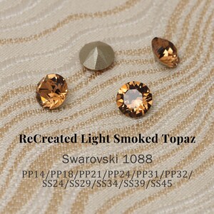 May include: Close-up of several ReCreated Light Smoked Topaz Swarovski crystals. The crystals are various shapes, including round and oval, and have a warm, amber color. The text "ReCreated Light Smoked Topaz" and "Swarovski 1088" are visible.