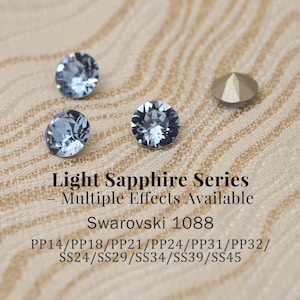 Puede incluir: Primer plano de cristales Swarovski azul claro y un perno de color dorado. La imagen incluye texto que dice "Light Sapphire Series - Multiple Effects Available Swarovski 1088". Se enumeran varios tamaños.