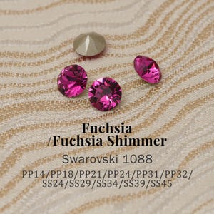 Pode incluir: Close-up de vários cristais Swarovski fúcsia. Os cristais são redondos e facetados, com um brilho brilhante. A imagem também inclui um cristal prateado. O texto na imagem diz "Fuchsia / Fuchsia Shimmer Swarovski 1088".