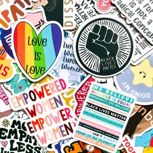 Puede incluir: Una colección de pegatinas coloridas con varios diseños y mensajes. Una pegatina presenta un corazón arcoíris con el texto "Love is Love". Otras pegatinas incluyen "Empowered Women", un puño de Black Lives Matter y declaraciones sobre igualdad y justicia social.