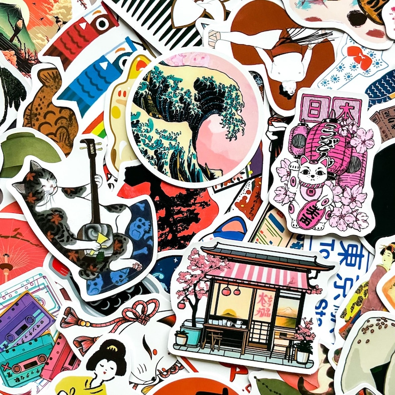 May include: A collection of colorful Japanese-themed stickers. Designs include a cat playing a shamisen, a lucky cat, a wave illustration, a traditional building, and other cultural motifs. The stickers are in various shapes and sizes.