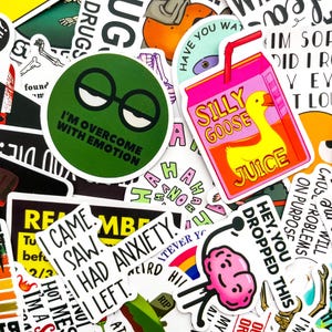 Puede incluir: Una colección de pegatinas coloridas con varios diseños y texto. Una pegatina es un círculo verde con gafas y el texto "I'M OVERCOME WITH EMOTION". Otra es una caja de jugo rosa con un pato y las palabras "SILLY GOOSE JUICE". Otras pegatinas tienen frases como "I CAME, I SAW, I HAD ANXIETY, I LEFT."