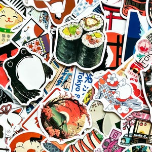 May include: A collection of colorful Japanese-themed stickers. The stickers feature sushi rolls, a frog, a koi fish, a cat, and a landscape with a mountain and cherry blossoms. Some stickers have Japanese text.