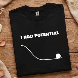 May include: A white ceramic mug with a black handle and the text "But First, Coffee" in a bold, black font. The mug is set against a blurred background, suggesting a cozy setting.