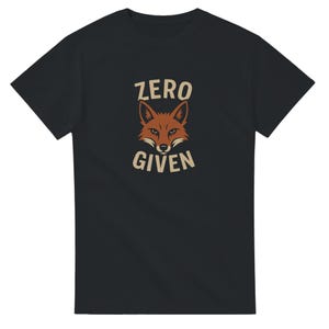 May include: Black t-shirt with a fox graphic and the words "ZERO GIVEN". The fox is brown, and the text is cream-colored. A casual tee for everyday wear.