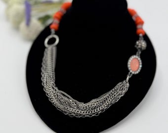 Masywny naszyjnik w stylu boho z pomarańczowymi koralami i srebrnym łańcuszkiem z frędzlami
