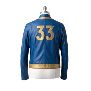 May include: A blue leather jacket featuring a gold collar and a gold hem. The back of the jacket displays the number 33 in large gold lettering. The sleeves have quilted detailing at the shoulders, and the jacket is displayed on a mannequin torso.