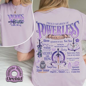 May include: Orchid-colored t-shirt with the text "VICIOUS little thing" on the front. The back features a graphic with the words "PROUD MEMBER OF POWERLESS BOOK CLUB" and other text and illustrations. The shirt is part of the Comfort Colors collection.