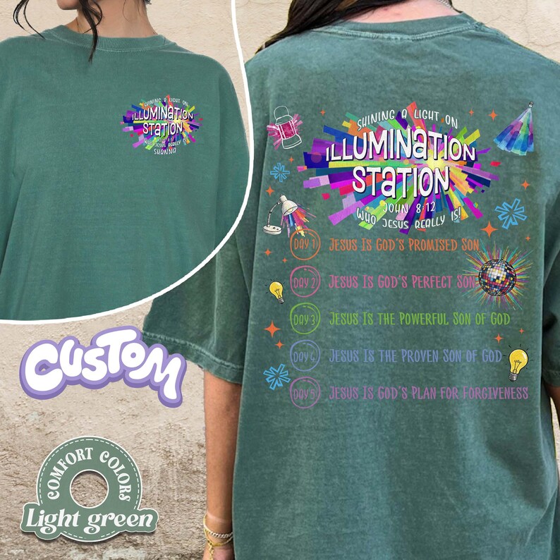 K&ouml;nnte beinhalten: Ein salbeigr&uuml;nes T-Shirt mit einer kleinen Grafik auf der linken Brust und einem gro&szlig;en, farbenfrohen Design auf der R&uuml;ckseite. Die R&uuml;ckseite zeigt den Text "SHINING A LIGHT ON ILLUMINATION STATION" mit verschiedenen Licht-Symbolen und religi&ouml;sen Texten.