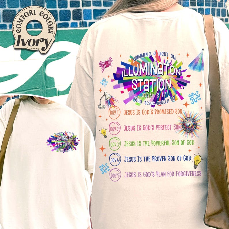 K&ouml;nnte beinhalten: Ein elfenbeinfarbenes T-Shirt mit einer bunten Grafik auf der R&uuml;ckseite und einer kleineren Version auf der Vorderseite. Das Design enth&auml;lt den Text "Shining a Light on Illumination Station" sowie eine Liste von f&uuml;nf Tagen mit religi&ouml;sen Themen.