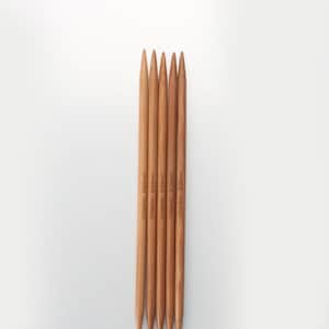 May include: Five wooden knitting needles with pointed tips. The needles are labeled with the text "ChiaoGoo 8 (50mm)" and "ChiaoGoo 8 (60mm)".