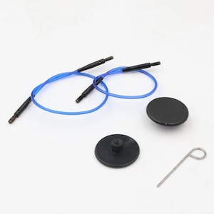May include: A knitting needle set with blue flexible cables, black connectors, and two black circular caps. A silver metal tool is also included. The items are arranged on a white surface.
