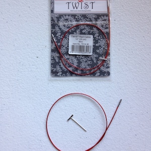 May include: Red 14-inch (35 cm) interchangeable knitting needle cable with two metal tips. The cable is packaged in a clear plastic bag with a label that reads "TWIST Red Cable 14" (35 cm) Mini Item No. 7514-M".