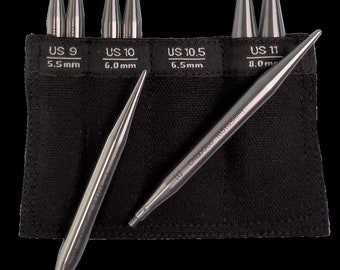 May include: A set of eight interchangeable knitting needles in a black zippered case. The needles are made of metal and are labeled with US sizes 9, 10, 10.5, and 11, with corresponding metric measurements in millimeters. The needles are arranged in the case by size.