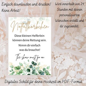 Könnte beinhalten: Digitales Hochzeitsschild mit dem Text "Notfallkörbchen" in goldener Schrift, umgeben von grünen und goldenen floralen Akzenten. Das Schild enthält den Satz "The show must go on" und weiteren deutschen Text. Zum Herunterladen und Drucken.