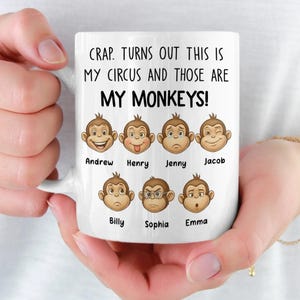 May include: White ceramic mug with the text "CRAP. TURNS OUT THIS IS MY CIRCUS AND THOSE ARE MY MONKEYS!". The mug features cartoon monkey faces with names below each face. The names are Andrew, Henry, Jenny, Jacob, Billy, Sophia, and Emma.