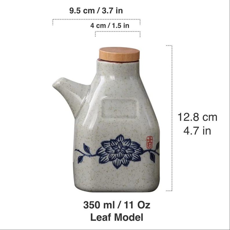 May include: A ceramic oil dispenser with a wooden lid, spout, and a blue floral design. The dispenser is 4.7 inches tall and holds 11 oz. The dimensions are 3.7 inches wide and 1.5 inches across the top. The text "Leaf Model" is at the bottom.
