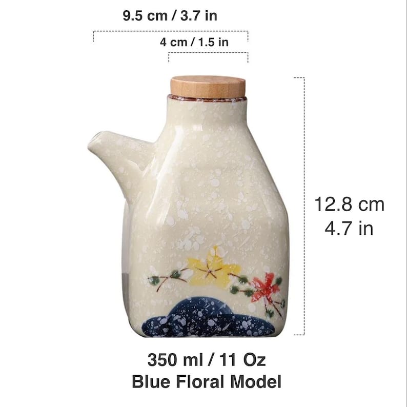 May include: Cream-colored ceramic oil dispenser with a wooden lid and a spout. The bottle is 4.7 inches tall and 3.7 inches wide, decorated with blue, yellow, and red floral designs. It holds 11 oz.