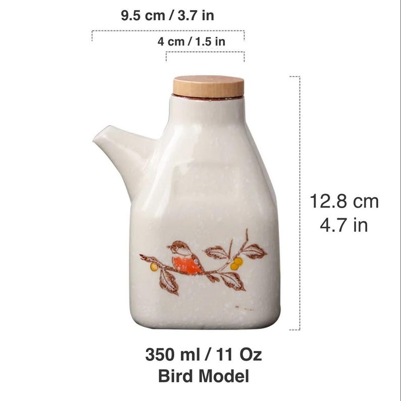 May include: A white ceramic oil bottle with a wooden lid and a spout. The bottle features a painted bird design and measures 4.7 inches tall, 3.7 inches wide, and holds 11 oz. The text "Bird Model" is at the bottom.