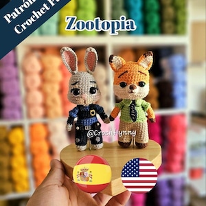 Puede incluir: Dos figuras amigurumi de ganchillo, un conejo con uniforme de policía azul oscuro y un zorro con camisa verde claro y corbata oscura. El texto dice Patrón amigurumi Crochet Pattern Zootopia @CrochHynny con banderas de España y EE. UU.
