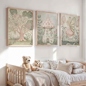 Puede incluir: Tres impresiones artísticas en acuarela enmarcadas con un tema caprichoso. Las impresiones presentan un árbol, una casa de champiñones y un hada. La obra de arte está en colores pastel suaves, con una cama de madera y osos de peluche en primer plano.