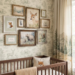 May include: A gallery wall featuring eight framed prints of woodland animals including a deer, bear, fox, and squirrel, displayed above a wooden crib with a fox-patterned pillow. The wall is covered in a light-colored wallpaper with a repeating forest scene.