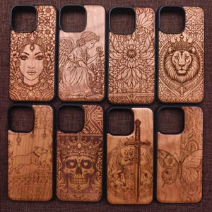 May include: A selection of wooden phone cases with detailed laser-etched designs. The cases display images such as a woman's face, an angel, a lion, a dog, a skull, a sword, a floral pattern, and a butterfly. Each case has a black border.