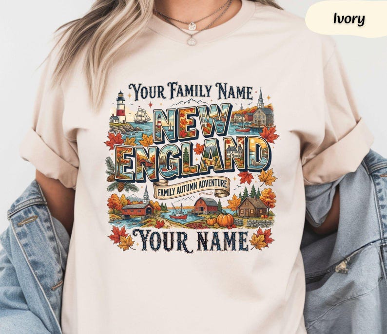 May include: An ivory t-shirt featuring a colourful graphic print with the text "YOUR FAMILY NAME", "NEW ENGLAND", "FAMILY AUTUMN ADVENTURE", and "YOUR NAME". The design includes illustrations of a lighthouse, a ship, autumn leaves, and cabins.
