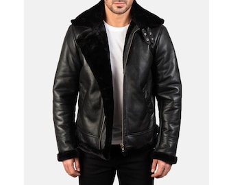 May include: Black leather jacket with a shearling lining and collar. The jacket has a zip-up front, a wide collar, and a classic aviator style. The cuffs and hem are also lined with shearling.