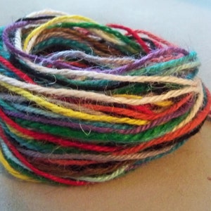 May include: A ball of colorful yarn with a variety of colors including red, green, yellow, blue, and white.