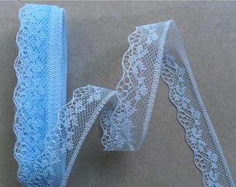 May include: Light blue lace trim with a scalloped edge. The trim is made of a delicate, soft material and has a subtle sheen.