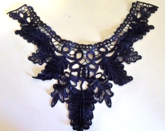 May include: A black lace trim with a floral design. The trim is delicate and intricate, with a scalloped edge.