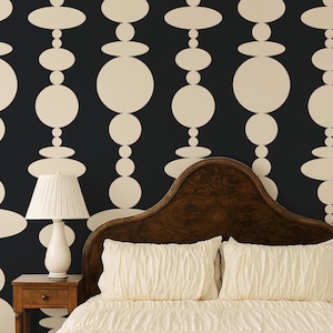May include: A dark charcoal wallpaper featuring a repeating vertical pattern of cream-colored circles and ovals of varying sizes. The design consists of stacked geometric shapes arranged in columns against a solid dark background.