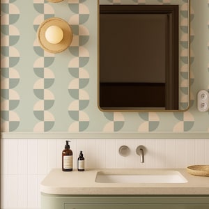 May include: A bathroom scene featuring a sage green vanity with a white sink and a gold-framed mirror. The wall has a geometric pattern in light blue and pink. Two woven sconces with round lights are mounted on the wall.