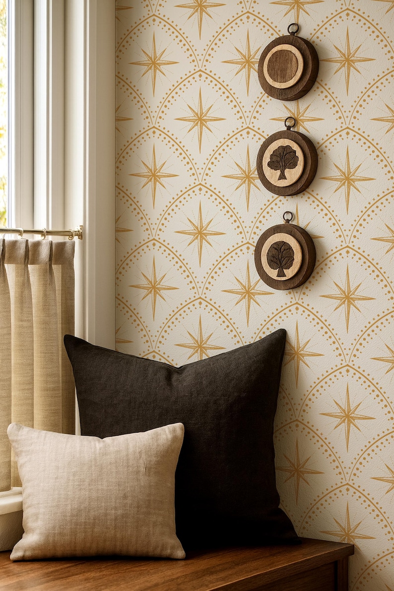 May include: Three circular wooden wall hangings featuring dark brown frames and light wood centers, two of which display a tree silhouette. These are mounted on a wall with a cream and gold starburst pattern, positioned above a dark and light pillow.