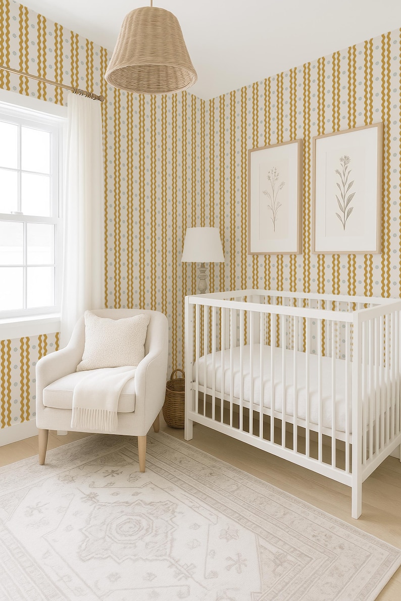 May include: A nursery room with a white crib, armchair, and a patterned rug. The walls are decorated with vertical stripes in gold and gray. Two framed botanical prints hang above the crib. A woven lampshade and a floor lamp complete the decor.