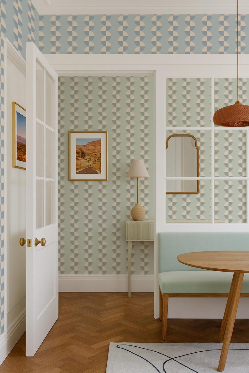May include: Interior scene with a light blue and beige geometric patterned wallpaper. A white door with gold hardware opens to reveal a room with a small table, bench, and a round wooden table. A framed landscape art piece hangs on the wall.