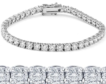 May include: A silver tennis bracelet with multiple round-cut diamonds. The bracelet features a secure clasp and is displayed against a white background. The diamonds are set closely together, creating a continuous sparkle.