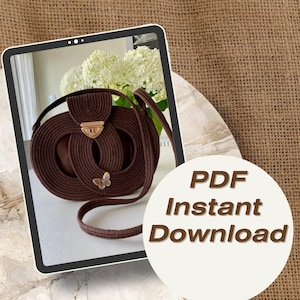 May include: A brown crochet handbag with a circular design, featuring a gold-coloured clasp and a butterfly embellishment. The bag has a long strap. Text on the image reads "PDF Instant Download."