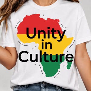 May include: White t-shirt featuring a colorful graphic of the African continent in red, yellow, and green. The words "Unity in Culture" are printed in black, with small star accents. The shirt is a casual wear item.