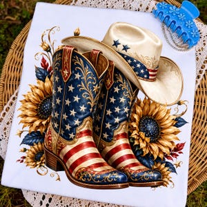 May include: A white t-shirt featuring a graphic print of two cowboy boots and a cowboy hat decorated with American flag patterns, stars, and stripes, surrounded by large yellow sunflowers with dark centers and intricate gold filigree accents.