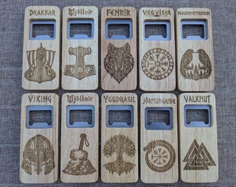 May include: Ten rectangular wooden bottle openers arranged in two rows. Each features a metal opener insert and laser-engraved Norse-themed designs and text, including Drakkar, Mjöllnir, Fenrir, Vegvisir, Huginn et Muninn, Viking, Yggdrasil, Jörmungandr, and Valknut.