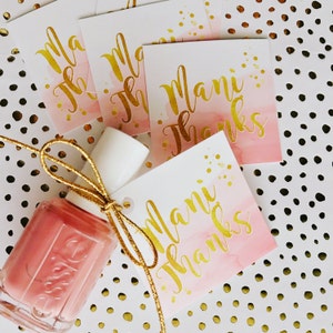 May include: Pink and white gift tags with gold glitter and the text "Mani Thanks". A pink nail polish bottle with a gold ribbon.