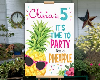 May include: A white sign with a pineapple wearing sunglasses and the text "Olivia is 5 It's time to party like a pineapple".