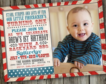 May include: A red, white, and blue birthday invitation with a photo of a baby boy. The invitation says "Stars, Stripes and Lots of Fun Our Little Firecracker's Turning One" and "Please Join Us As We Celebrate Drew's 1st Birthday With a Backyard BBQ Saturday July 4th 2015 4:00PM".