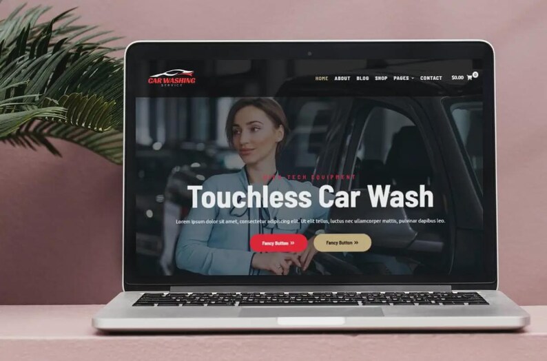 K&ouml;nnte beinhalten: Ein Laptop zeigt eine Website f&uuml;r eine Autowaschanlage. Der Bildschirm zeigt eine Frau in einem blauen Hemd mit dem Text "Touchless Car Wash". Die Website hat eine rote und eine goldene Schaltfl&auml;che. Der Laptop steht auf einer rosa Oberfl&auml;che.