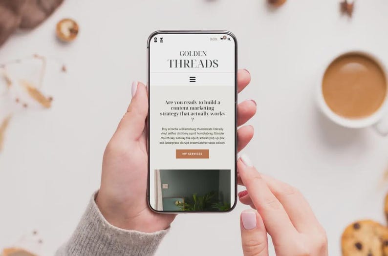 Puede incluir: Un tel&eacute;fono inteligente muestra el sitio web "GOLDEN THREADS" con el texto "&iquest;Est&aacute;s listo para construir una estrategia de marketing de contenidos que realmente funcione?" El tel&eacute;fono lo sostiene una persona.