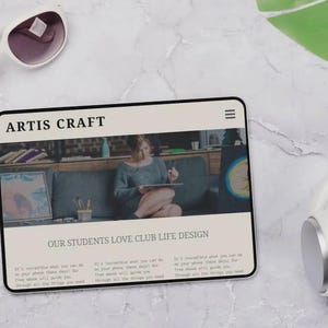 Puede incluir: Una tableta digital que muestra el texto "ARTIS CRAFT" y "OUR STUDENTS LOVE CLUB LIFE DESIGN". La pantalla muestra a una persona usando una tableta. Tambi&eacute;n se ven gafas de sol blancas y auriculares.
