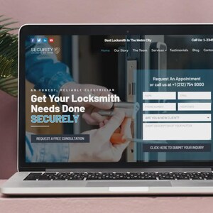 May include: A laptop displays a website for a locksmith service. The screen shows the text "Get Your Locksmith Needs Done SECURELY" and a form to request an appointment. The laptop is on a pink surface.